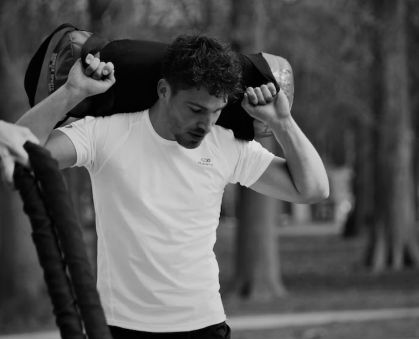 Hombre con bolsa de deporte y camiseta blanca sin marcas de sudor gracias a bótox