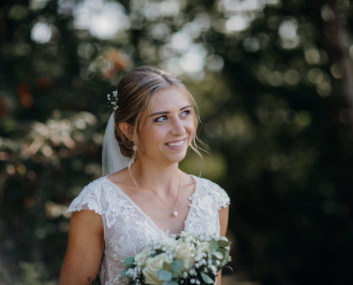 Novia vestida de blanco con ramo de flores que se ha sometido a tratamiento estético